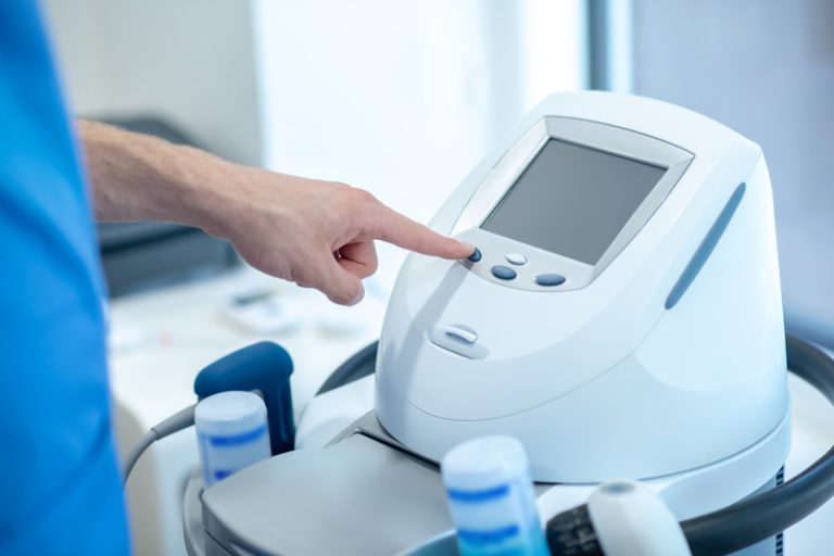 Ultrasound,Therapy.,Close-up,Of,Male,Hands,Pressing,Buttons,On,Physiotherapy